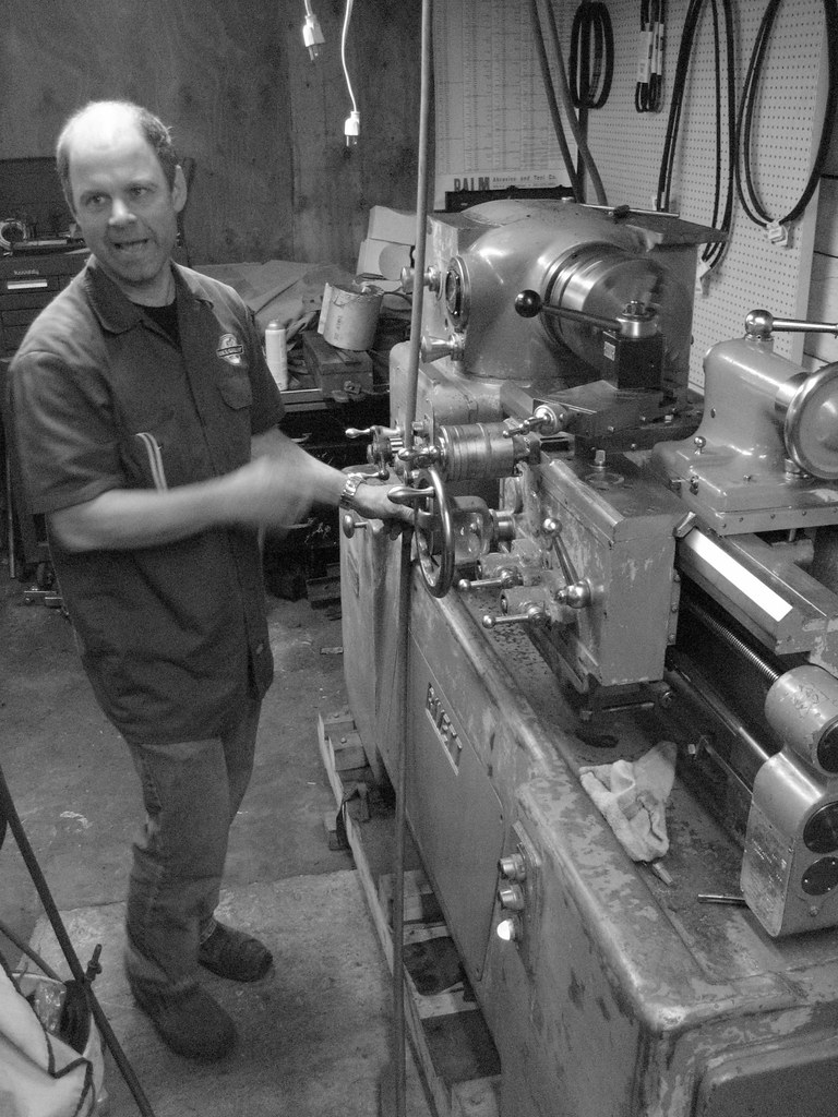 Brett Flemming standing at a lathe